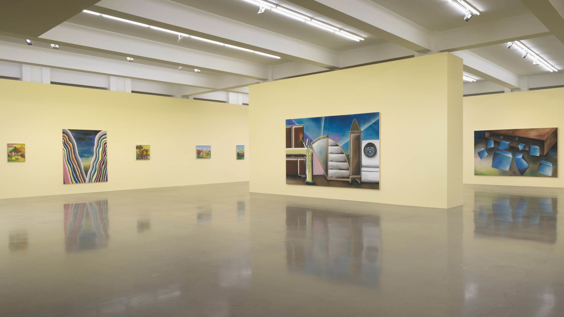 Modern art gallery interior with cream walls displaying various paintings including colorful abstract works, landscape scenes, and geometric compositions on polished floors