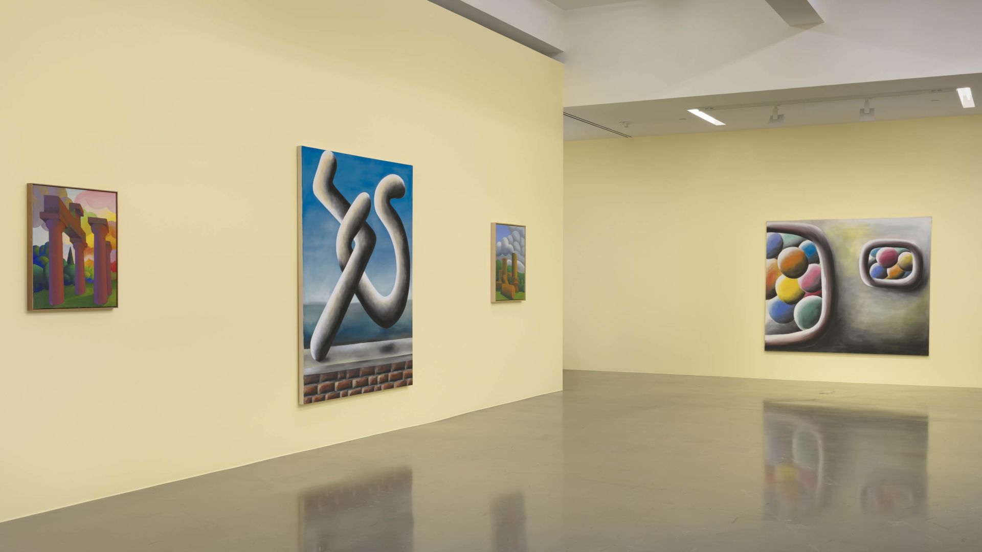 Gallery view showing multiple artworks including surreal sculptures, abstract paintings, and colorful contemporary pieces on white walls