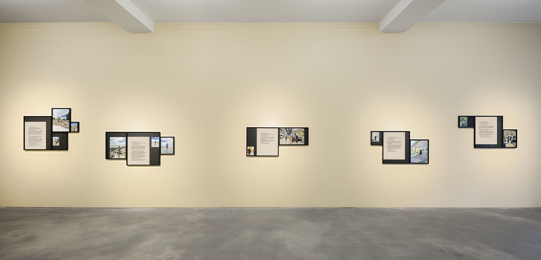 Gallery wall showing five framed pieces in a row, each containing text and photographic elements documenting various performance locations.
