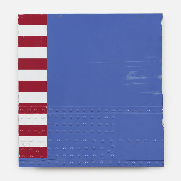 Abstract art piece featuring a blue rectangular field with red and white stripes on the left side. The surface has visible rivets or dots, suggesting industrial materials