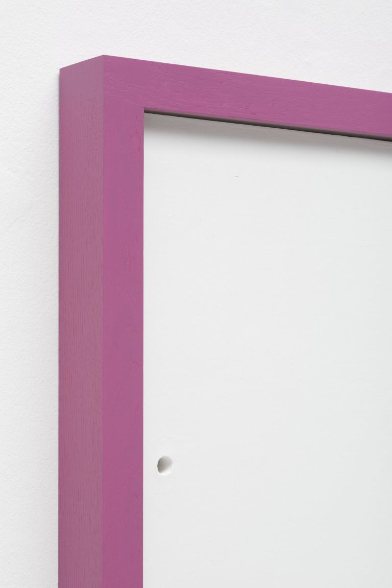 Minimalist white square artwork with pink colored borders mounted on white wall. It features a small black hole near the left edge.