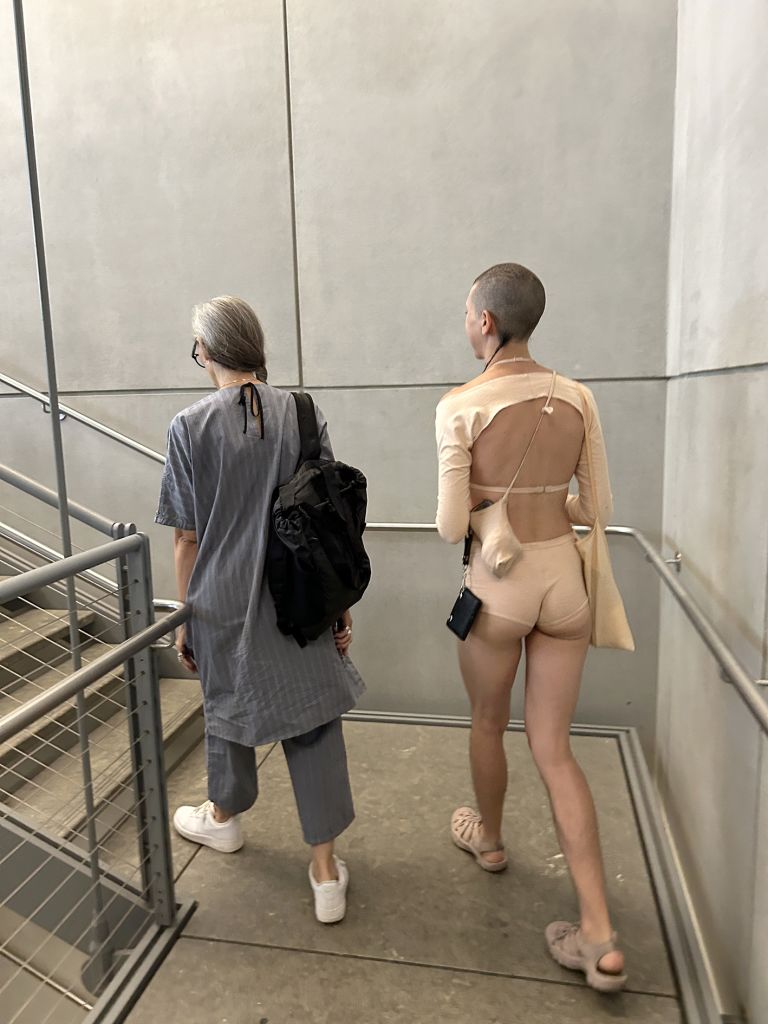 Black-framed display showing text and multiple photographs documenting performance art in various indoor gallery and museum settings.