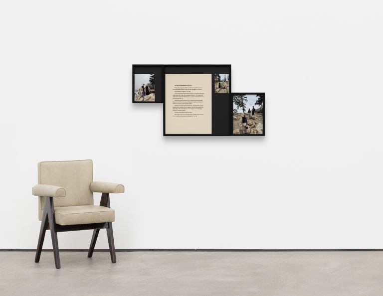 Framed artwork displaying text and photographs of performance art conducted in rocky, mountainous outdoor terrain with multiple participants.