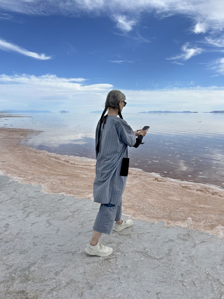 Large frame with text and two photographs showing performance in desert salt flat landscape with expansive sky and distant mountains.