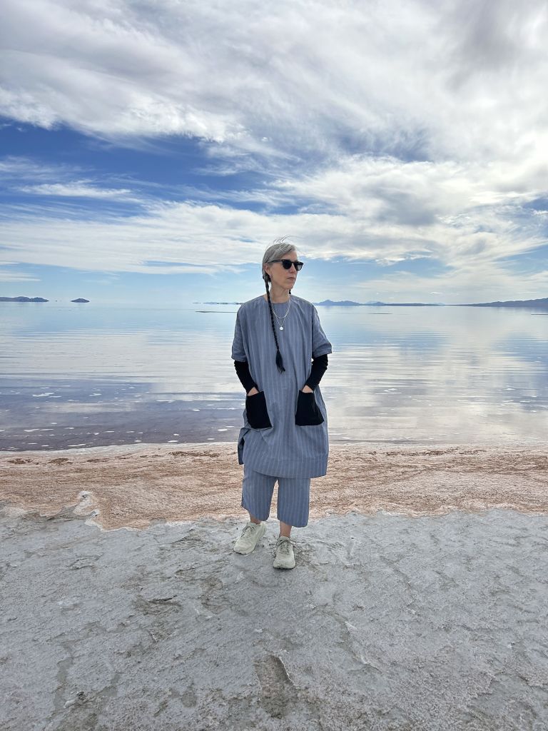 Large frame with text and two photographs showing performance in desert salt flat landscape with expansive sky and distant mountains.