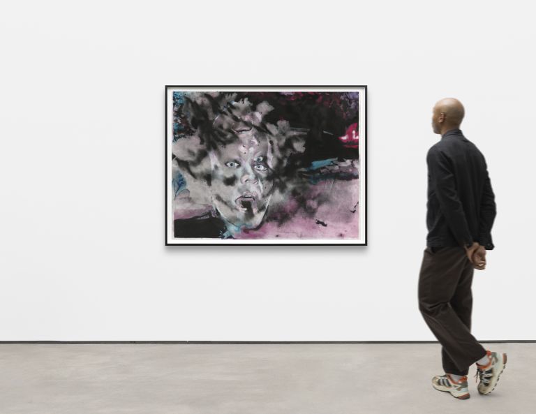 Colorful abstract portrait showing a face emerging from pink, blue, and gray watercolor splatters and washes, framed in black.