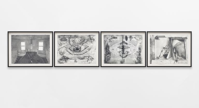 Four framed black and white artworks displayed in a row on white gallery wall.