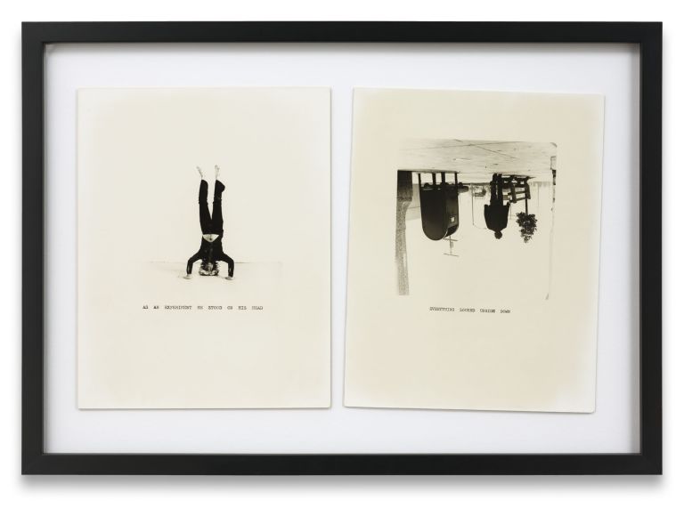 Two framed artworks: left shows inverted figure with text, right shows upside-down street scene with buildings