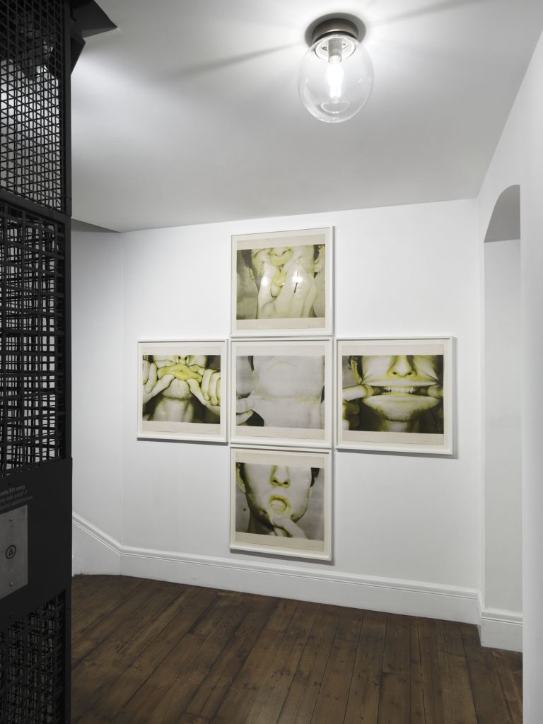 Five framed photographs arranged in a cross pattern showing close-up images of hands covering facial features, tinted yellow-green