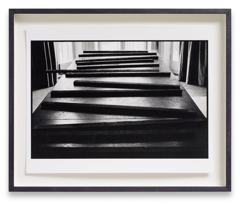 Six identical framed photographs in a horizontal row showing perspective view down a wooden pier or boardwalk in black and white