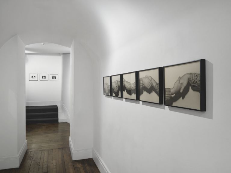 Five framed black and white photographs in a row showing different handshake positions between two people wearing different sleeves