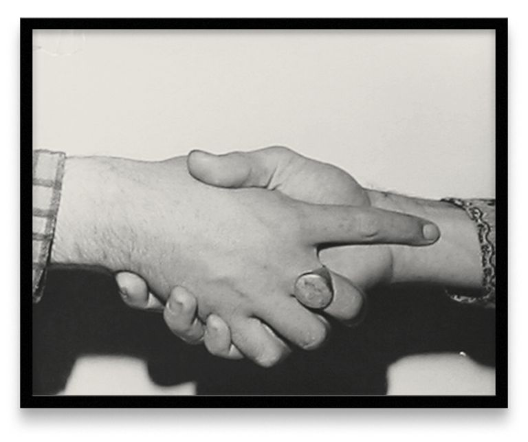 Five framed black and white photographs in a row showing different handshake positions between two people wearing different sleeves