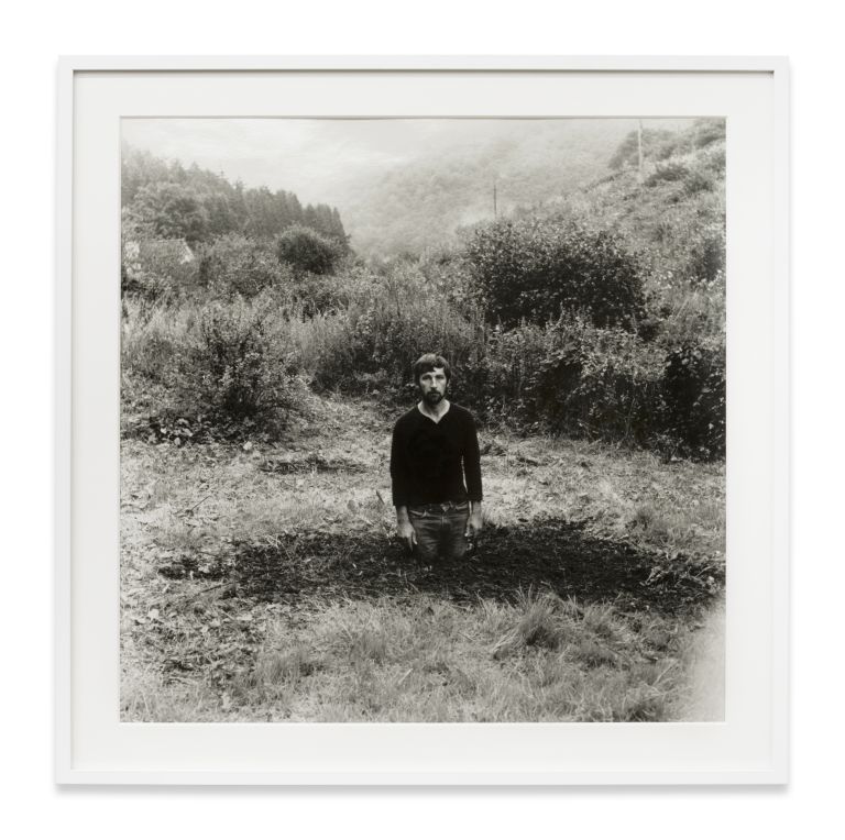 Grid of nine identical black and white photographs showing a person gradually disappearing into a landscape.