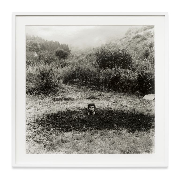 Grid of nine identical black and white photographs showing a person gradually disappearing into a landscape.