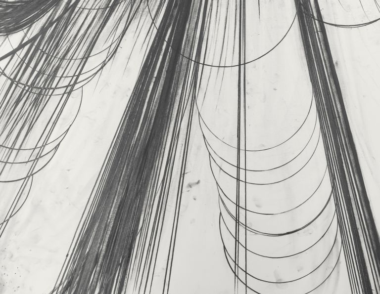 Framed abstract drawing of circular black graphite explosion with sweeping curved lines below