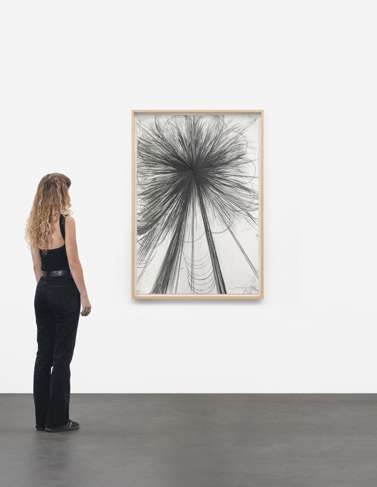 Framed abstract drawing of circular black graphite explosion with sweeping curved lines below