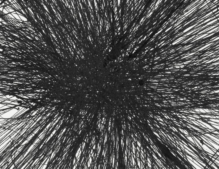 Framed drawing with explosive black graphite marks radiating outward, matted in white frame