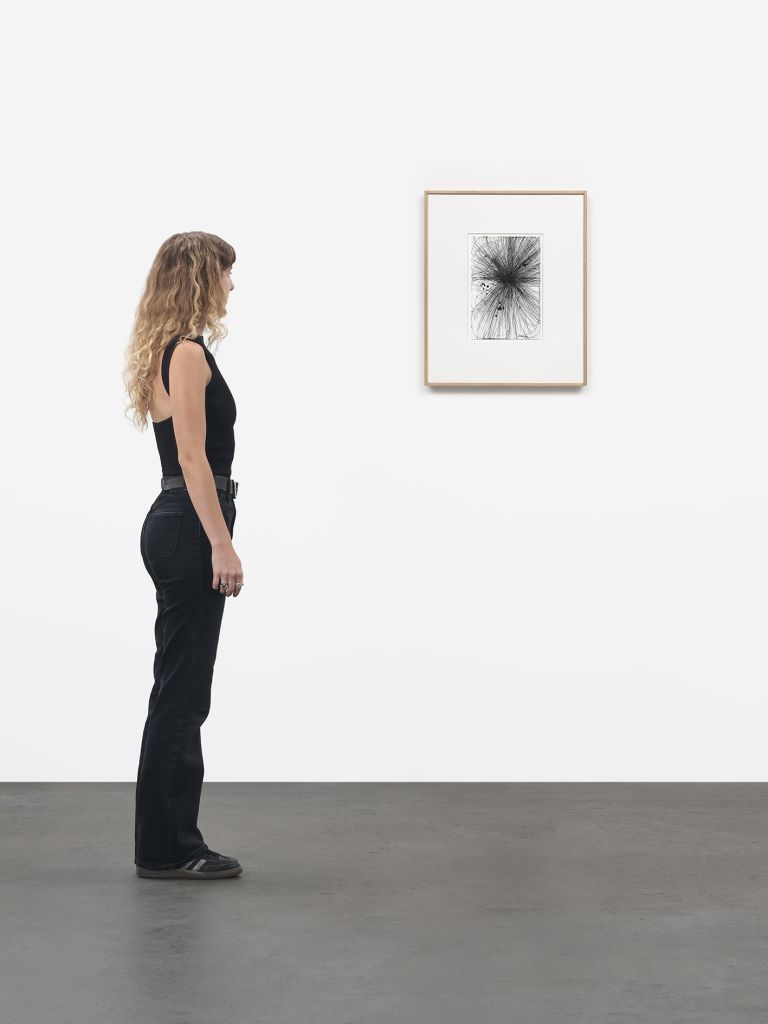 Framed drawing with explosive black graphite marks radiating outward, matted in white frame