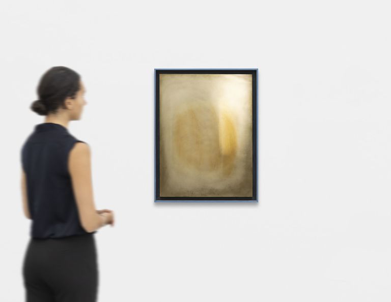 Abstract painting in warm golden tones with two soft amber oval forms glowing against a pale cream surface.