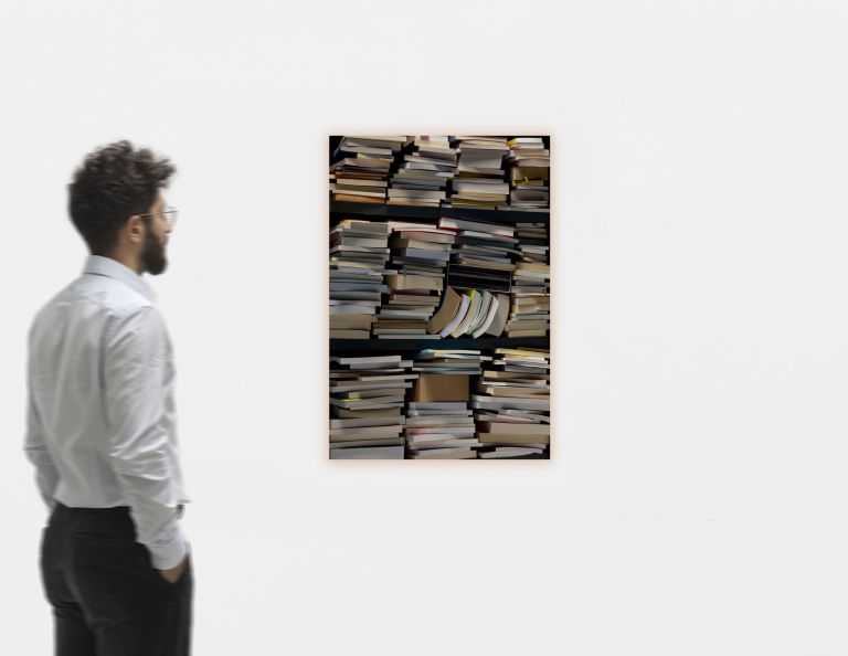 Photo of stacked books piled in towers against dark background, one book falling open mid-air.