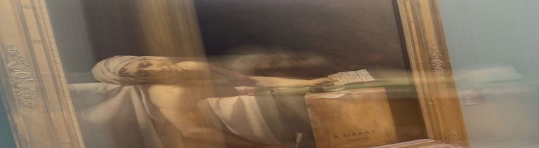 Blurred close-up photograph of Jacques-Louis David's "Death of Marat" painting behind glass, slightly tilted, in a museum.