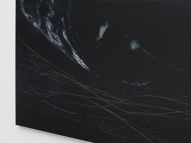 Large dark canvas showing turbulent nocturnal seascape with luminous mauve-orange clouds and engraved white lines.