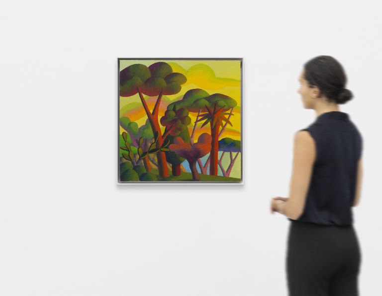 Colorful expressionist painting of stylized trees with curved trunks in red, green, and purple against a yellow sky with rolling hills