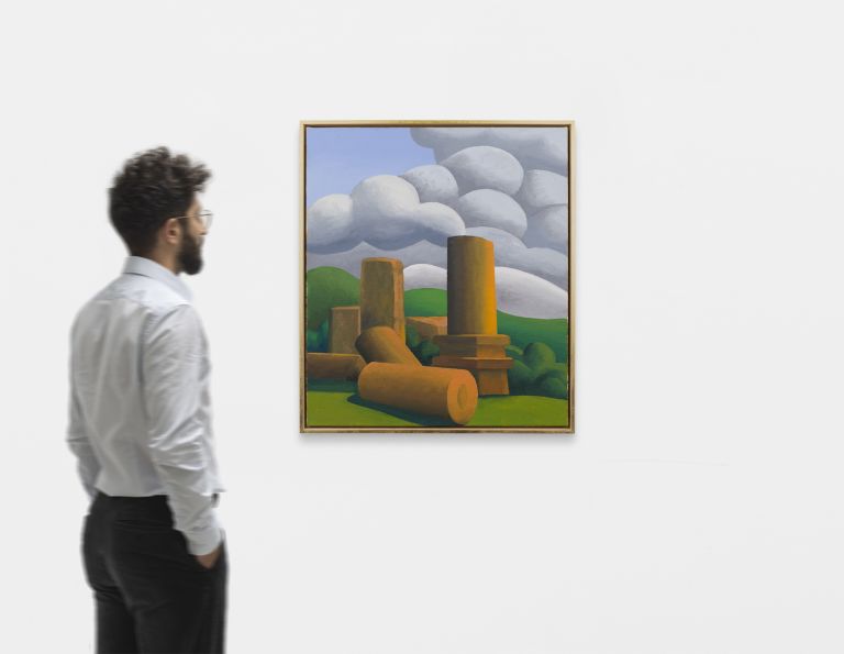 Painting of ancient ruins with cylindrical columns and scattered stone blocks under dramatic gray and white clouds in green landscape