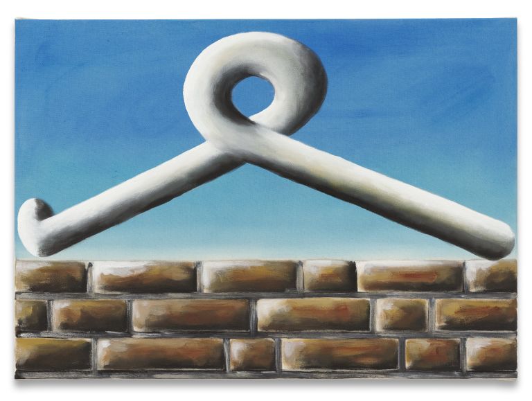 White sculptural form with angular geometric shape featuring triangular and curved elements against blue sky above brick foundation