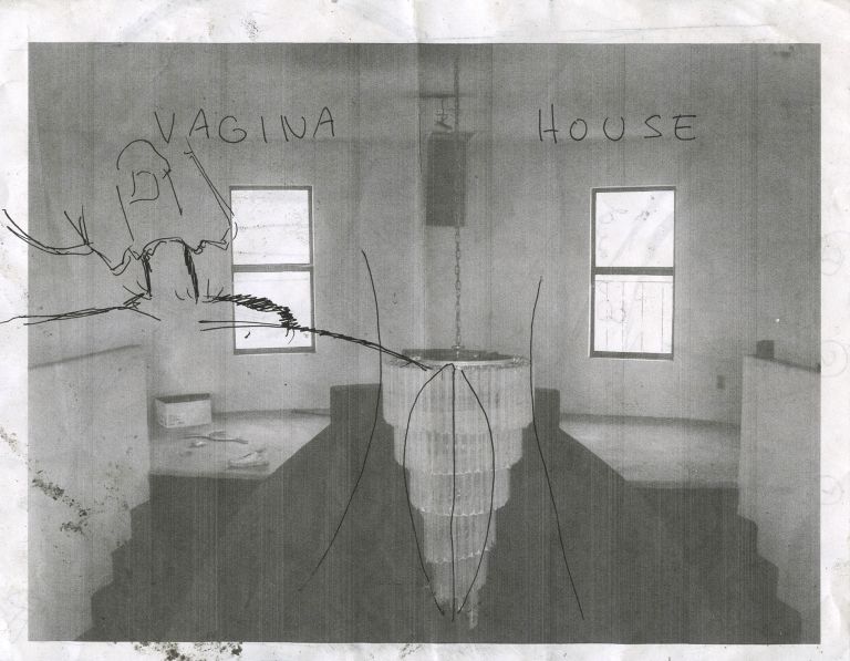 Black and white photograph of gallery installation titled "VAGINA HOUSE" with sculptural elements and windows.