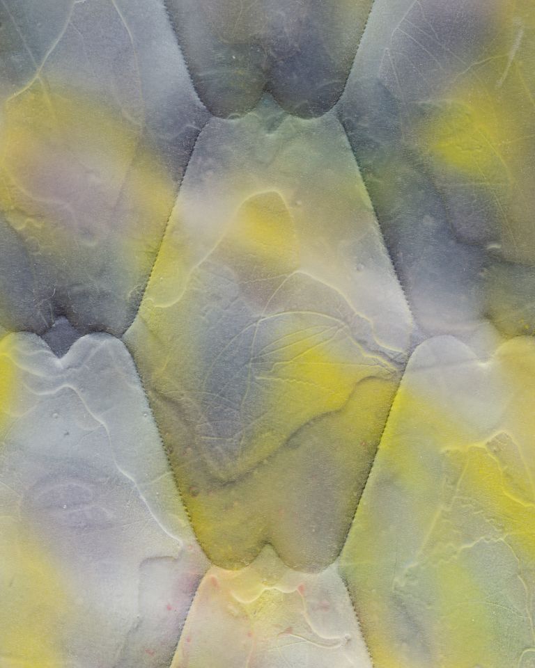 Painted mattress artwork with yellow and gray hexagonal pattern mounted vertically on white gallery wall.