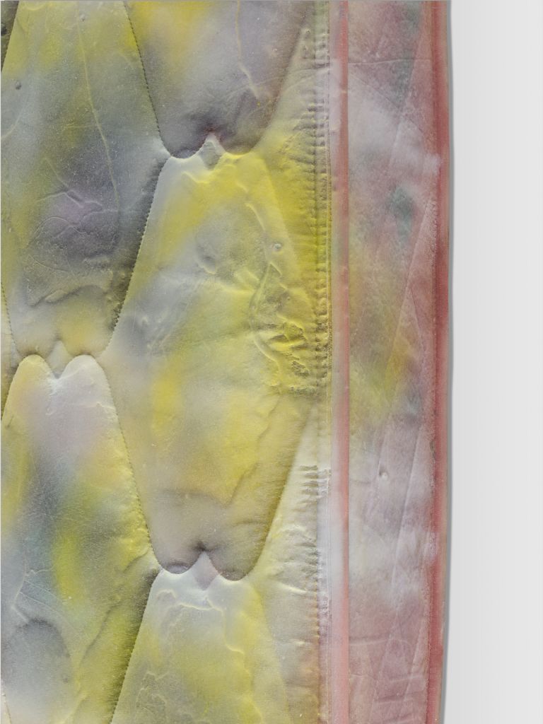 Painted mattress artwork with yellow and gray hexagonal pattern mounted vertically on white gallery wall.