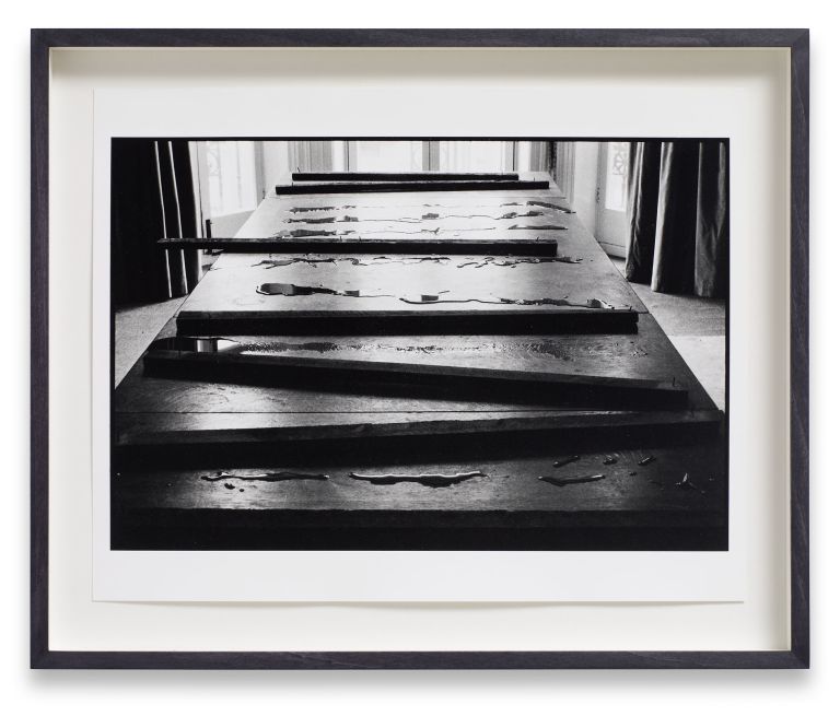 Six identical framed photographs in a horizontal row showing perspective view down a wooden pier or boardwalk in black and white