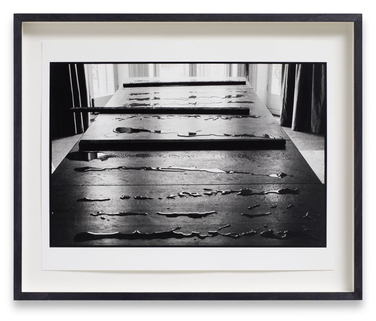 Six identical framed photographs in a horizontal row showing perspective view down a wooden pier or boardwalk in black and white