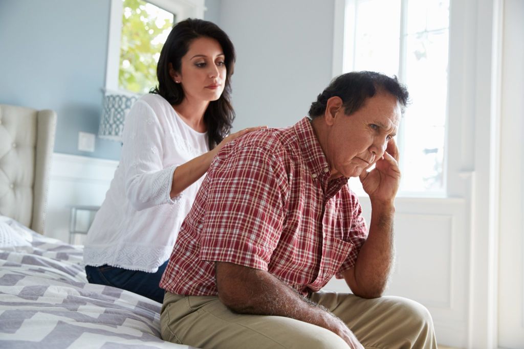 Adult Daughter Comforting Father Suffering With Alzheimers
