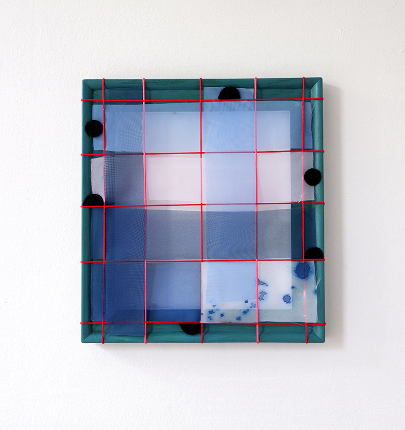 A square abstract artwork with a translucent grid woven and stretched over a frame. The frame is dark green with a red cord grid, layered with blue and violet panels. Black circular shapes punctuate the surface, and small blue stains appear in the lower right.