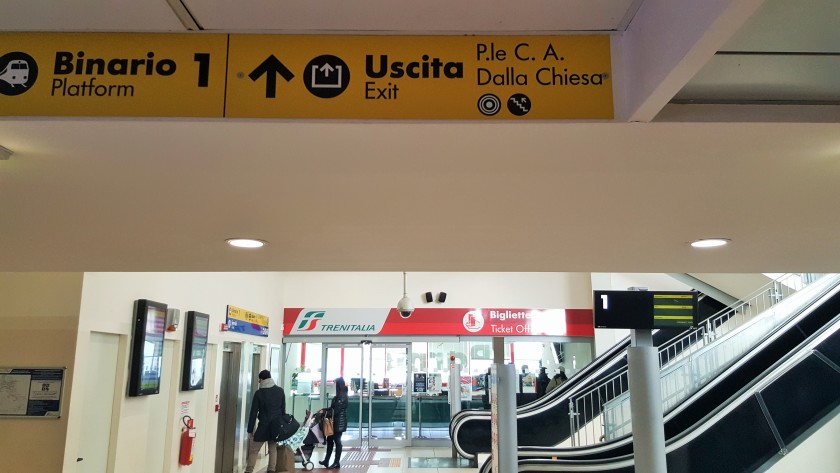 From the passage beneath the trains, the exit is at the top of the escalators and elevators