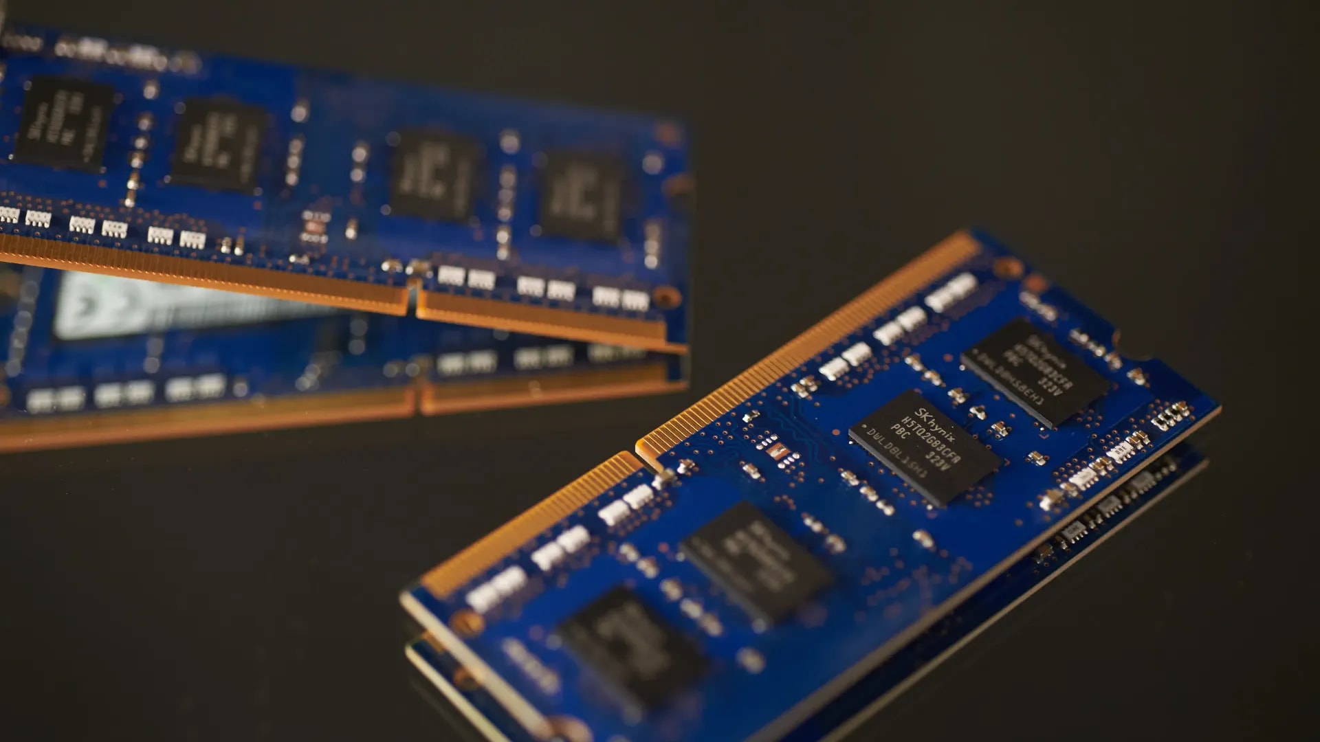 A 16:9 professional close-up shot of DDR4 and DDR5 RAM modules installed on a motherboard with dramatic lighting.