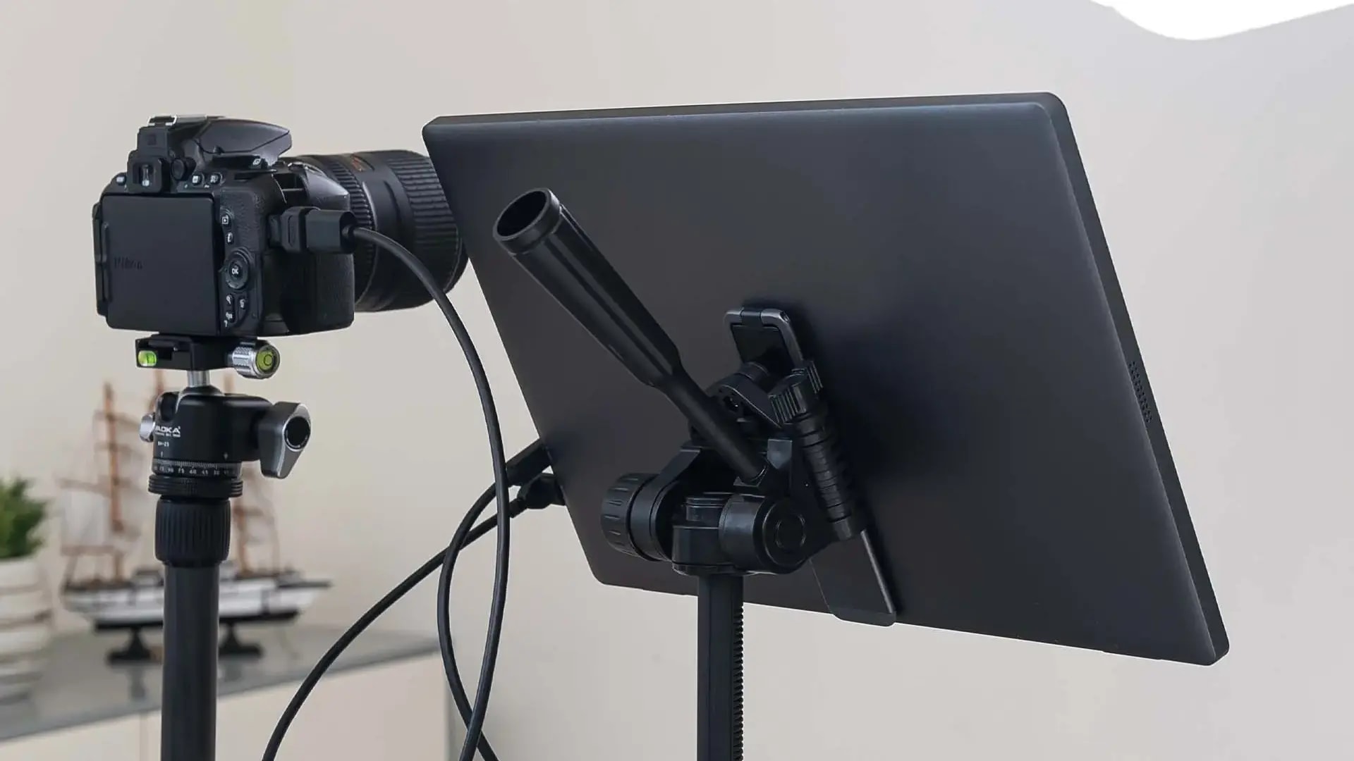MSI PRO MP161 E2 mounted on a tripod stand, showing USB-C connection from behind.
