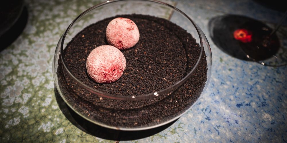 Two balls of whitish red on a bed of coffee beans.