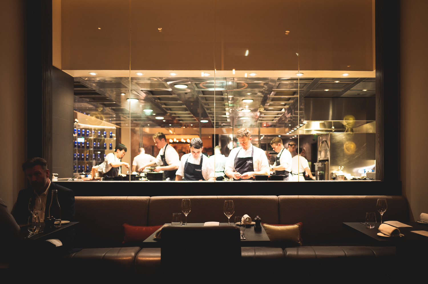 The chefs working away, visible from the dining area through a large pane of glass.