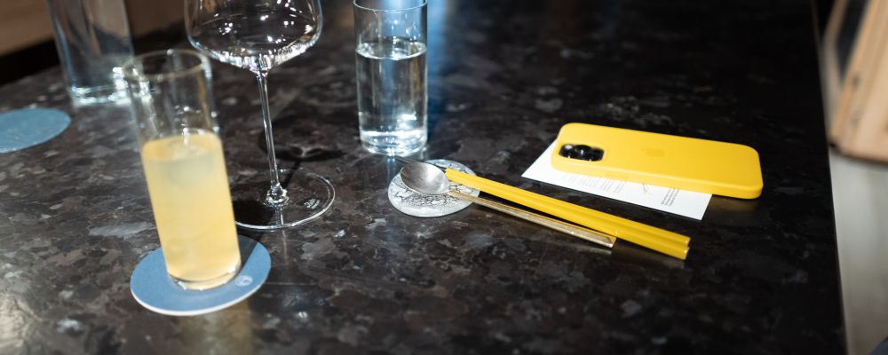 A yellow cocktail with yellow chopsticks with a yellow phone.