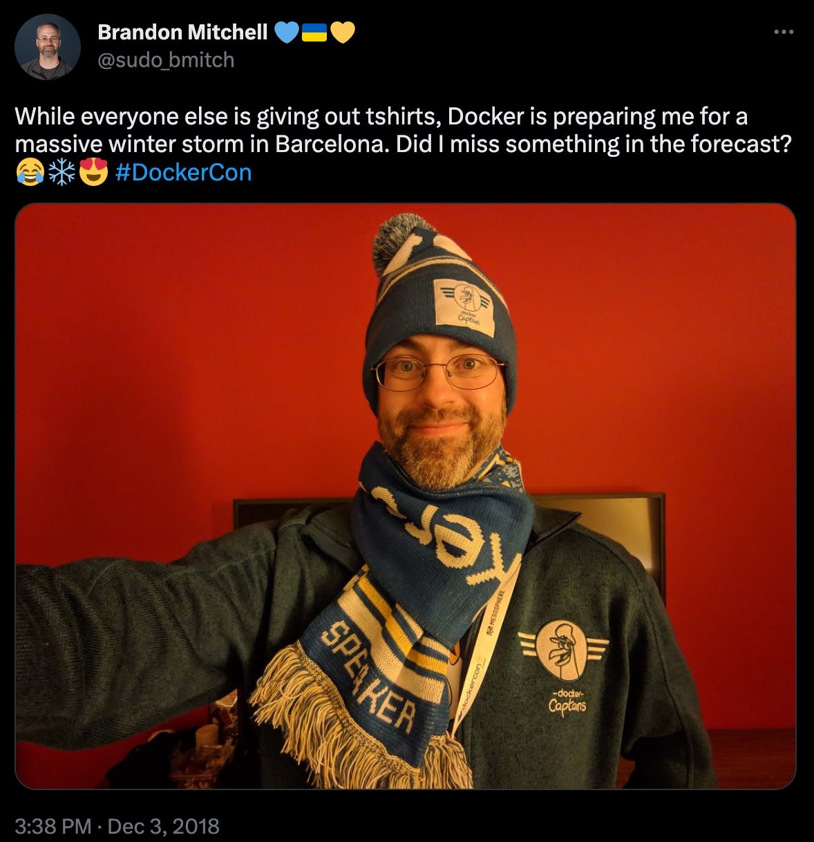 Captura de tela de um post no Twitter com Brandon Mitchell agasalhado e usando produtos do Docker. Legenda: "Enquanto todos distribuem camisetas, o Docker está me preparando para uma grande tempestade de inverno em Barcelona. Perdi algo na previsão?"