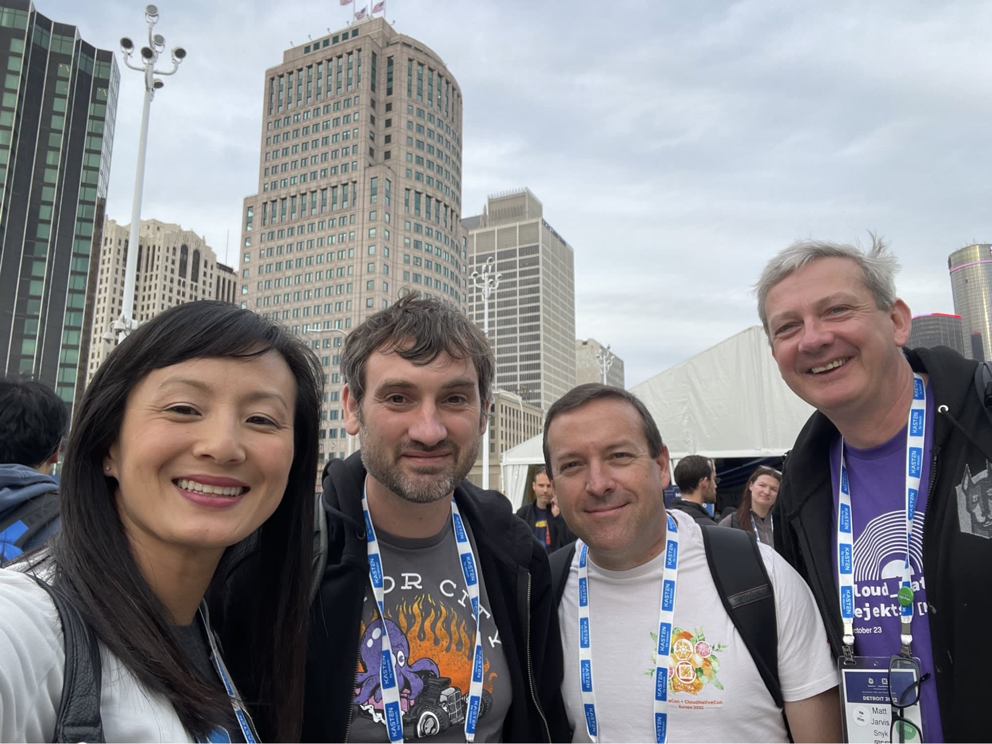 Selfie com Betty Junod, Adrian Mouat, Eric Smalling e Matt Jarvis, com arranha-céus ao fundo. Foto tirada durante o Kubecon North America 2022, em Detroit, Michigan.