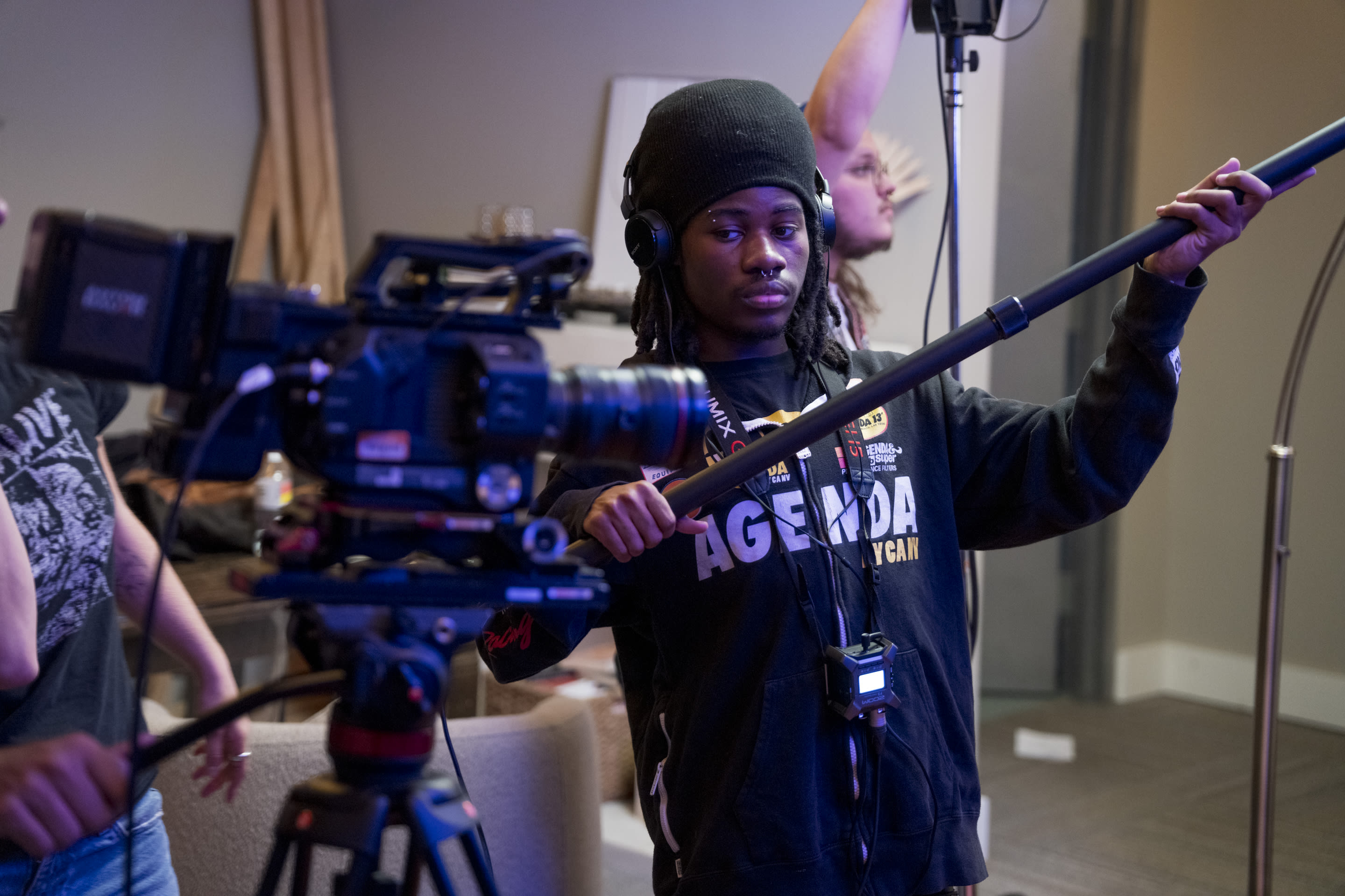 City Cinema student with a boom microphone on a professional set