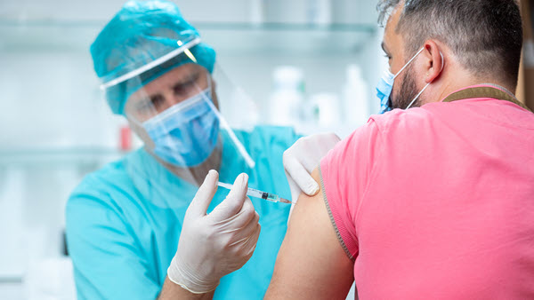 Man getting vaccinated at mass vaccination clinic.