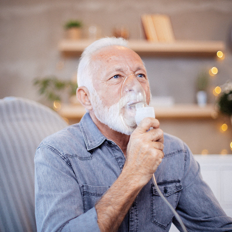 Man with shortness of breath receiving supplemental oxygen by mask