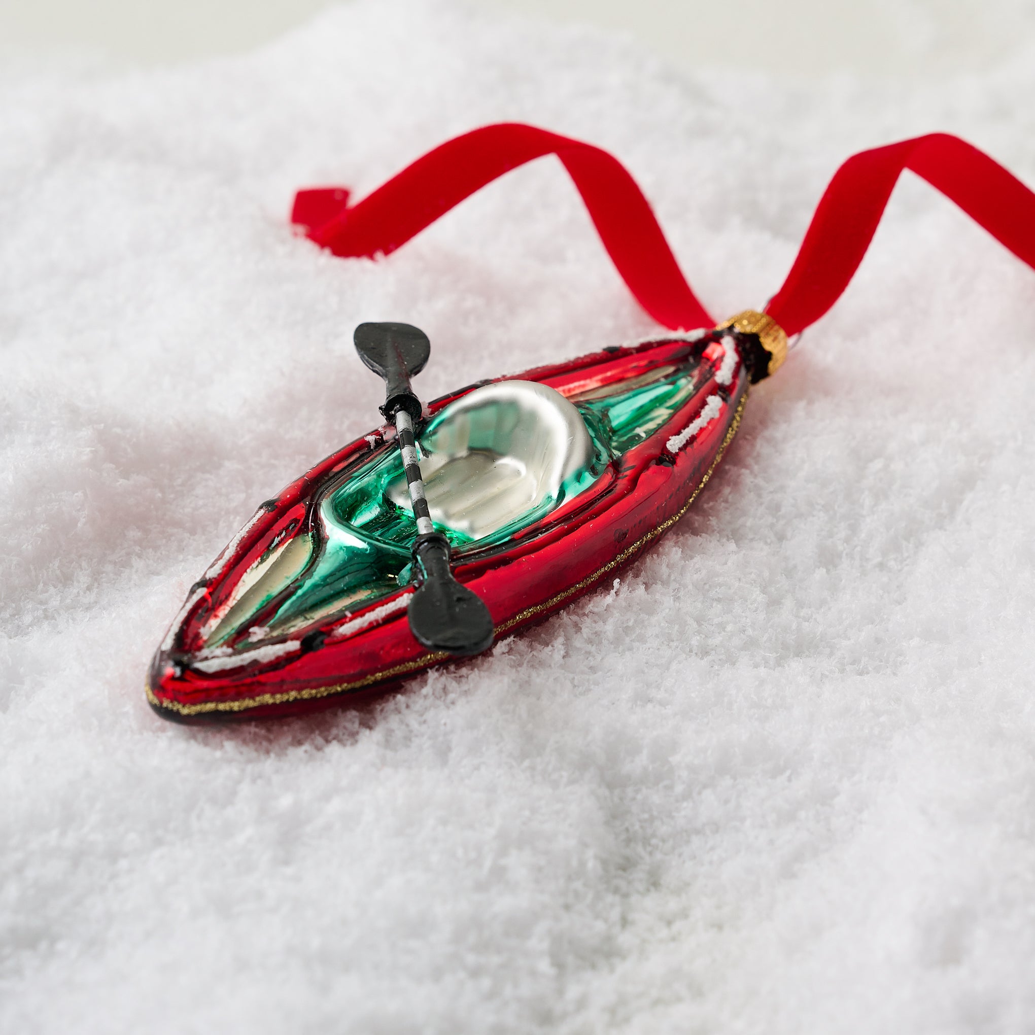 Glass Kayak Ornament shown in snow