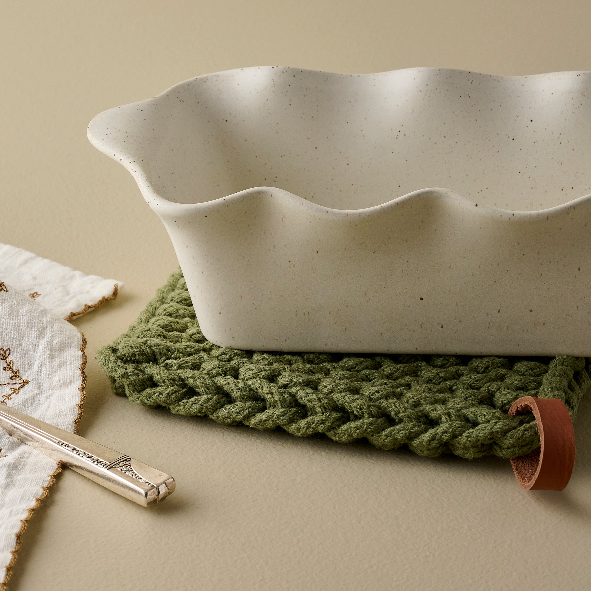 French White Scalloped Loaf Pan shown up close on pot holder