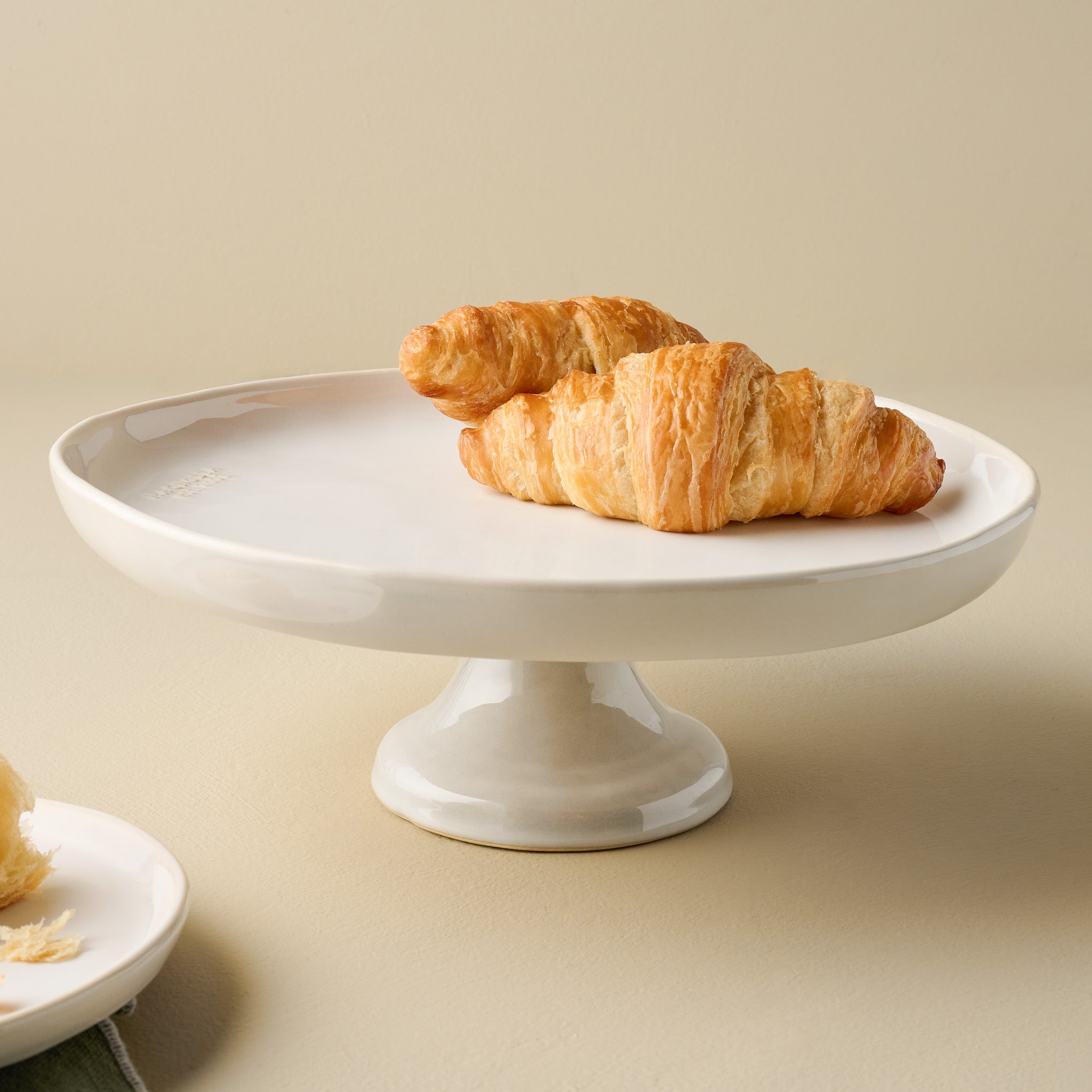 Magnolia Est. Cake Stand in use with croissants $42.00